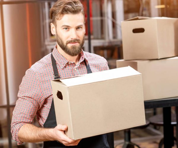 Portrait of professional courier with boxes delivering packages at the manufacturing.